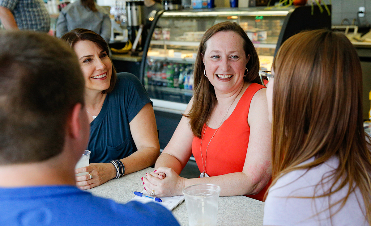 Photo of Kristin talking with constituents at a coffee shop.